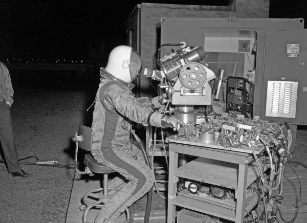 Astronaut in Spacesuit Testing Relief Optics For Apollo Guidance & Navigation System Astronaut in Spacesuit Testing Relief Optics For Apollo Guidance & Navigation System