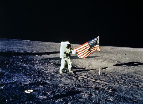 Apollo 12 Astronaut with American Flag on Lunar Surface